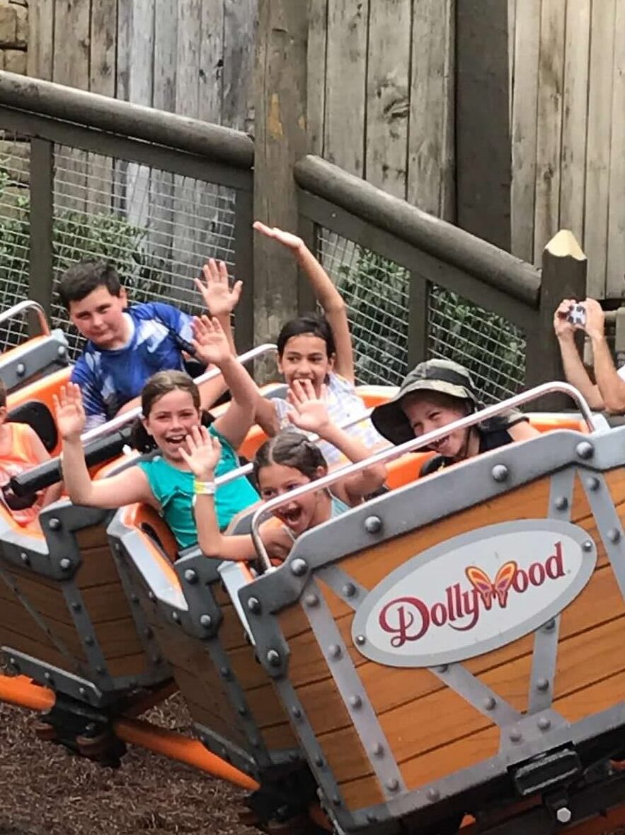 Kids with hands above their heads on a rollercoaster at Dollywood in Tennessee.