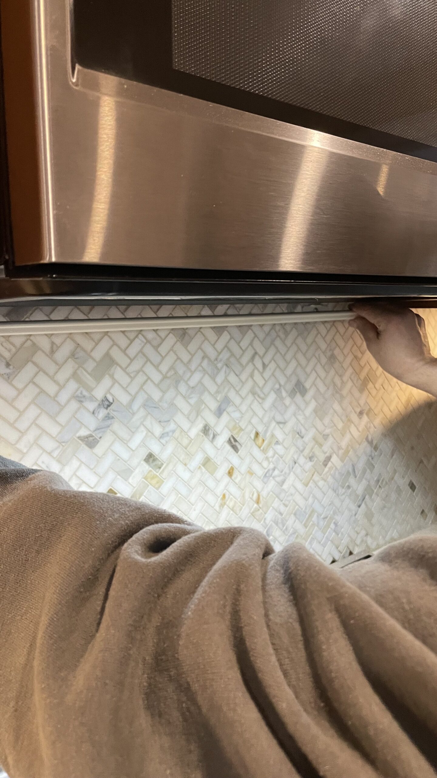 Installing metal channel under microwave for under cabinet lighting.